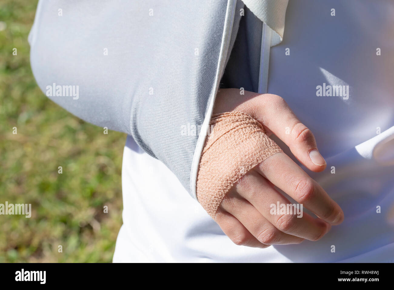 A boy with an injured hand in a fixing bandage on the background of a  football field, meadows Stock Photo - Alamy