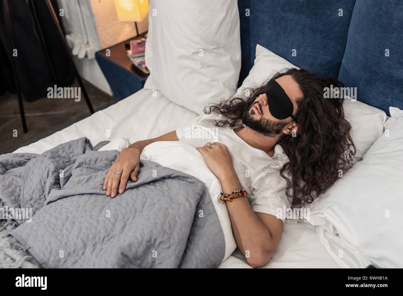 Nice bearded man wearing a special sleeping mask Stock Photo