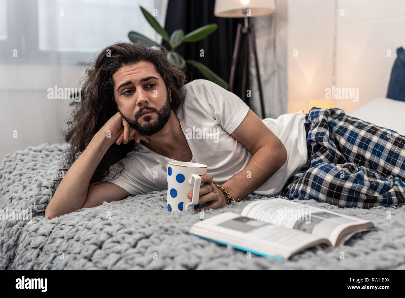 Sad thoughtful young man drinking hot tea Stock Photo - Alamy
