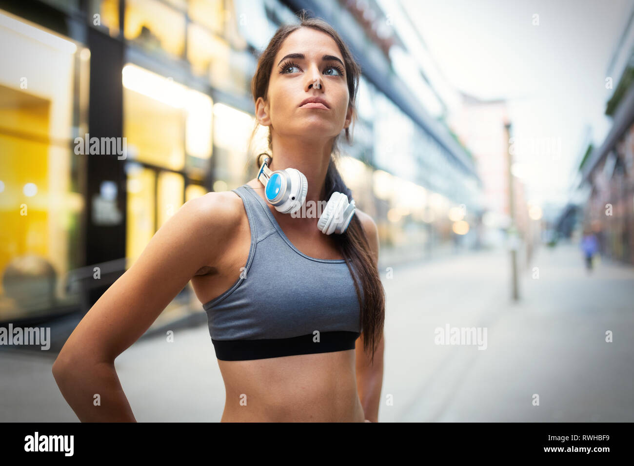 Young fit woman listening to music and working out by running Stock Photo
