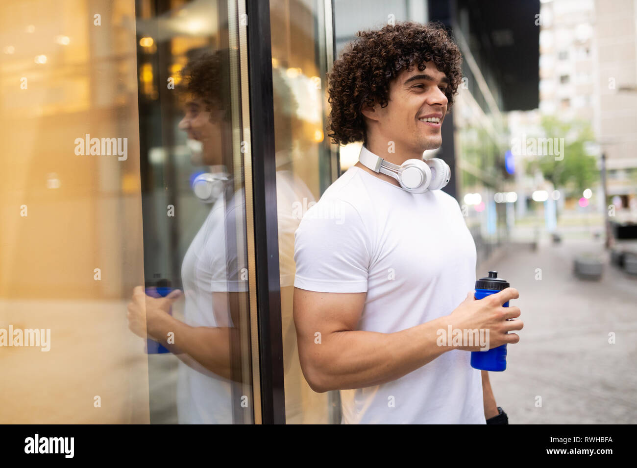 Handsome runner man drinking fresh water in urban area Stock Photo