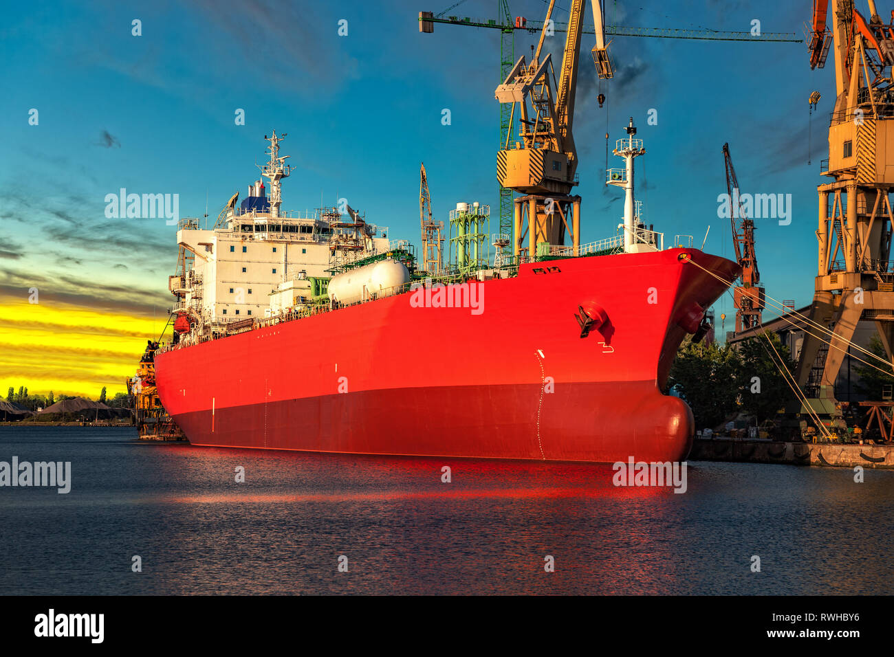 Cargo ship in port at sunset time. Stock Photo