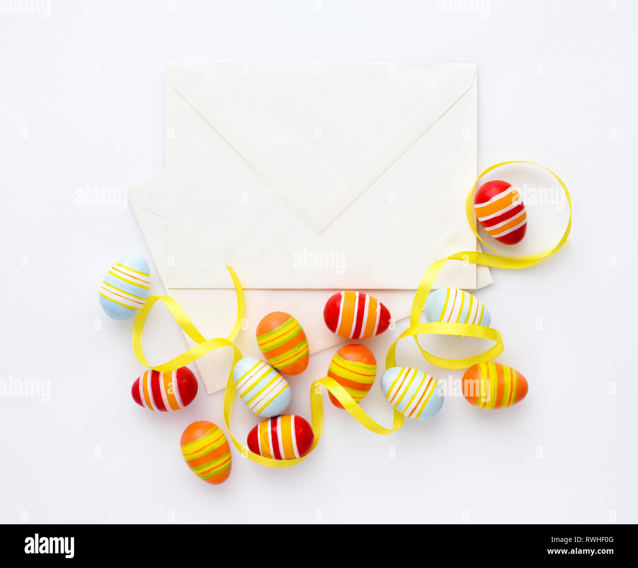 Festive background with easter eggs with ribbons and envelopes. Top view Stock Photo