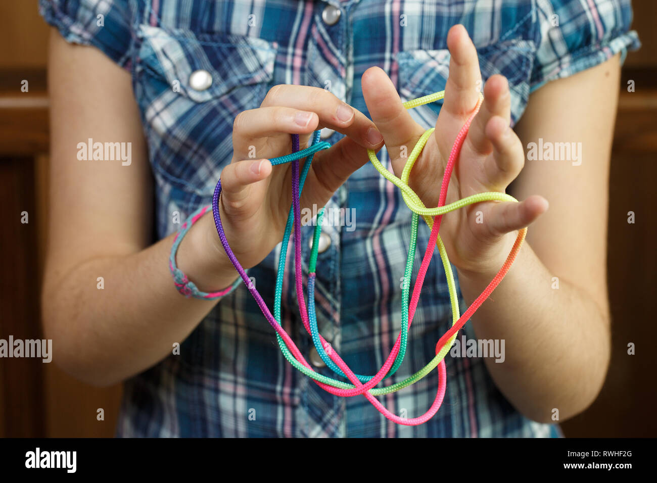 Child playing classic, oldschool string game and didactic toy with her