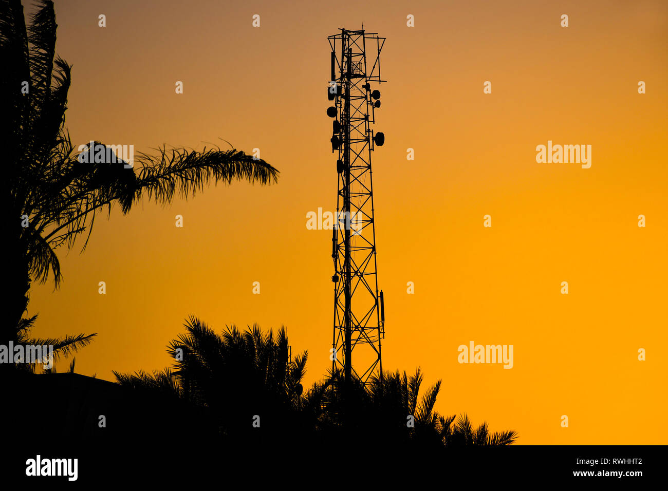 Silhouette of telecommunication antenna cellular tower for mobile signal network with beautiful sunset sky background Stock Photo