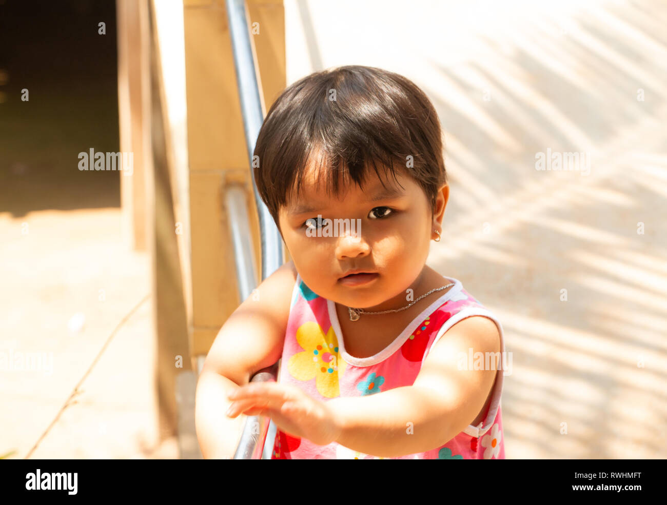 Cute, smiling, happy pre school age Vietnamese girl outside her home, Tan Chau, An Giang Province, Mekong Delta, Vietnam Stock Photo