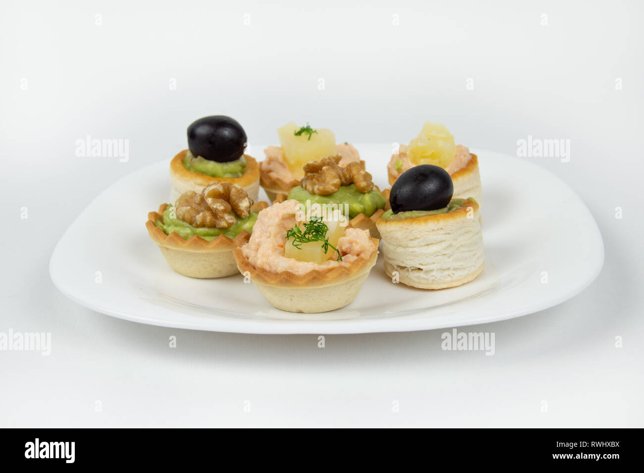 Several beautiful tartlets with different fillings on a white background Stock Photo