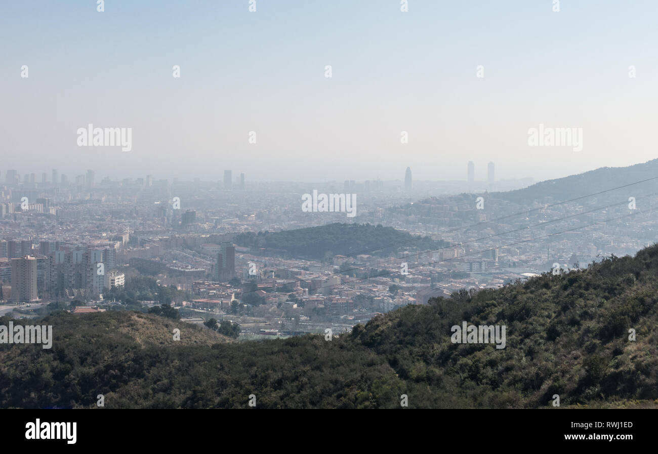 Overview of the polluted city of Barcelona, from the Collserola mountain, with a layer of smog over it. Barcelona, Catalonia, Spain Stock Photo