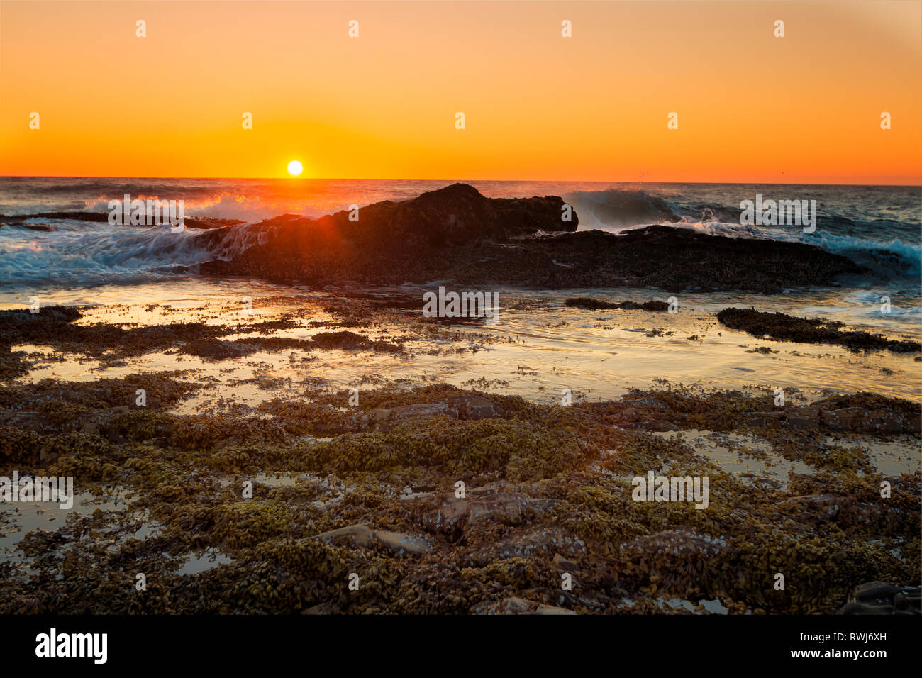 Sun dropping below the horizion at Green Point, Gros Morne National Park, Newfoundland and Labrador Stock Photo
