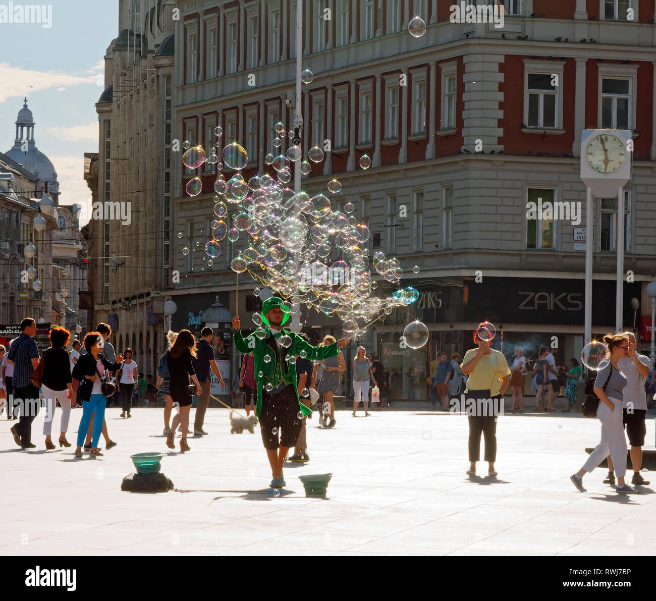 costumed man, waving bubble wands; clear bubbles; people; Trg Bana Jelacica; Jelacic Square; pedestrian zone; job, Zagreb; Croatia; Europe; summer; ho Stock Photo