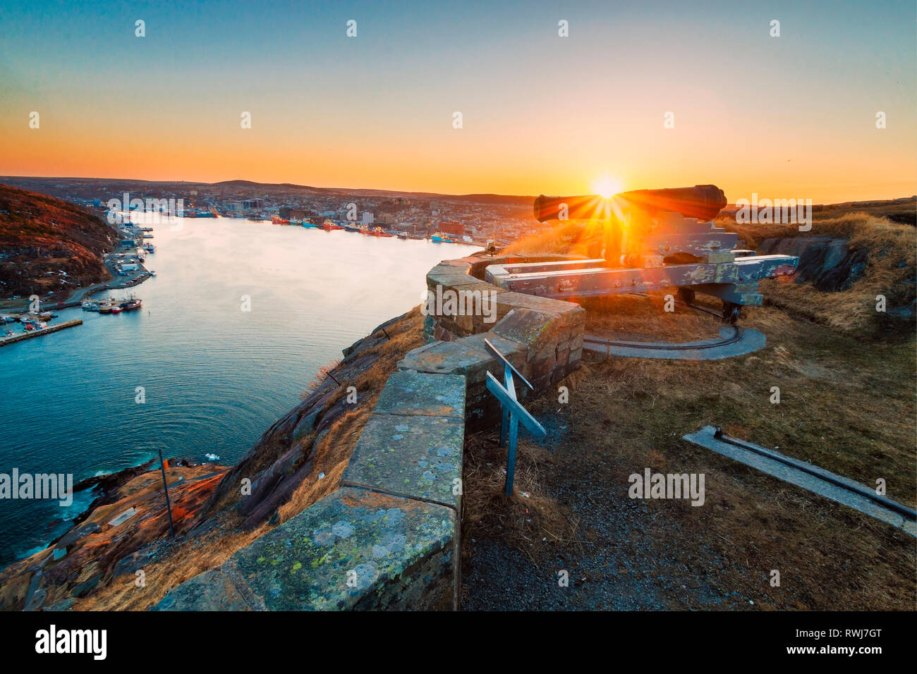 view of the sun setting behind the city of St. John's from the Queens Battery, Signal Hill National Historic Site, St. John's, Newfoundland and Labrador Stock Photo