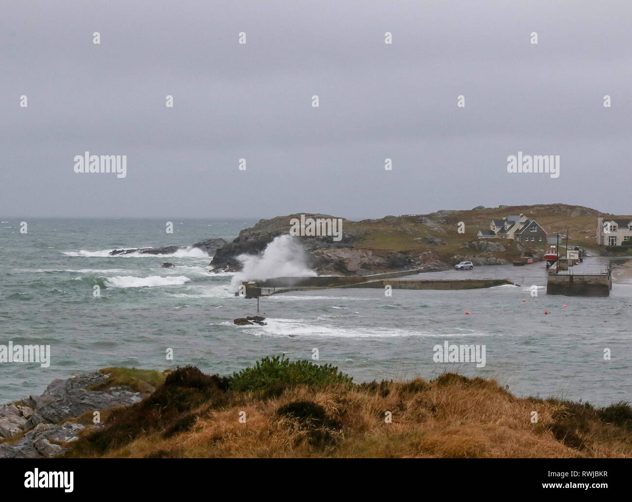 County Donegal, Ireland. 06 March 2019. Ireland weather - after heavy overnight rain, it was a day of strong winds and driving rain across County Donegal. Waves crashing over the harbour wall at Portnablagh. Credit: David Hunter/Alamy Live News. Stock Photo