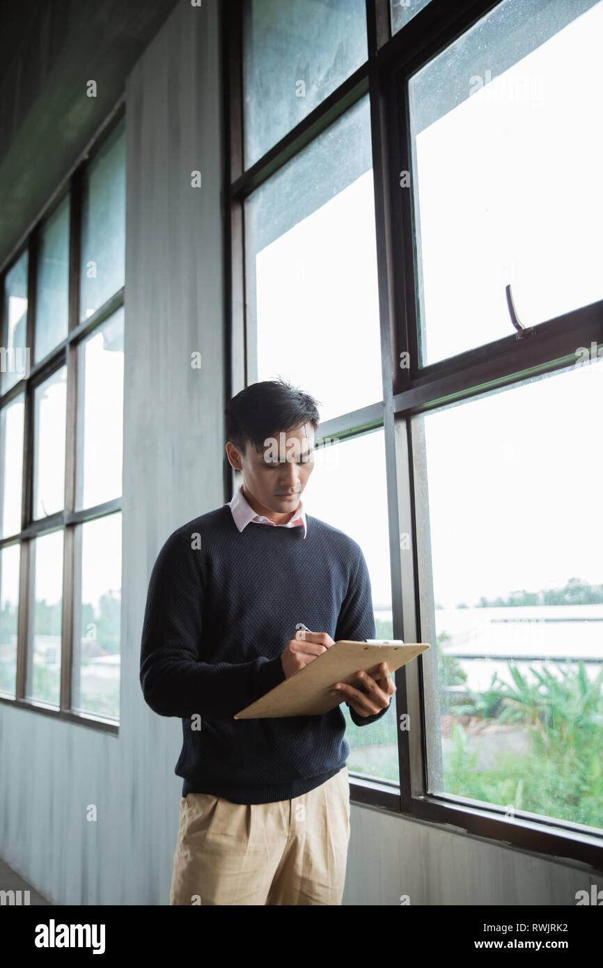 concept of asian man worker standing write on a clipboard Stock Photo ...