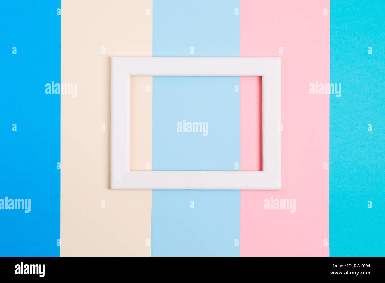 Abstract pastel colorful paper background with white wooden frame, flat lay with copy space Stock Photo