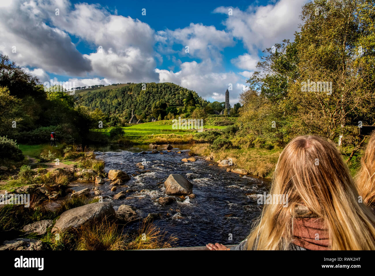 Tourists view St. Kevin's Church and round tower in the distance at Glendalough; County Wicklow, Ireland Stock Photo