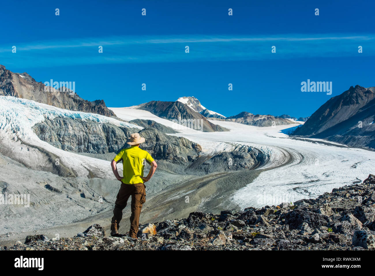 A man walks in Gulkana Glacier Valley in the Eastern Alaska Range in South-central Alaska on a sunny summer afternoon Stock Photo