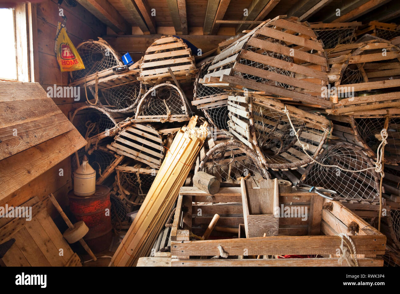Lobster traps stacked on top of each other and materials for repairing them stored in a fishing shed at Broom Point Fishing Premises, Gros Morne National Park, Parks Canada, Western Newfoundland, Canada Stock Photo