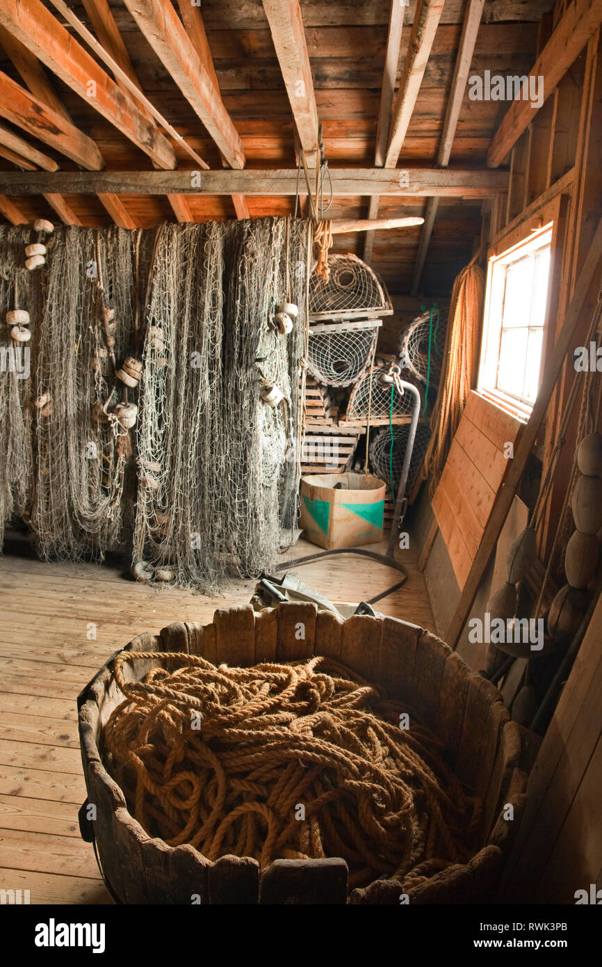 Nets, lobster traps and other fishing gear stored in a fishing shed at Broom Point Fishing Premises, Gros Morne National Park, Parks Canada, Western Newfoundland, Canada Stock Photo