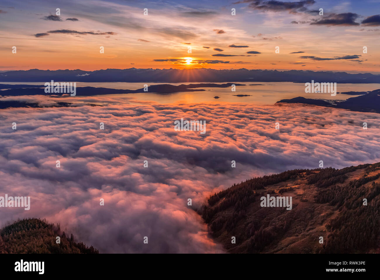 View across Lynn Canal from above Herbert Glacier and Chilkat Mountains at sunset, Southeast Alaska; Alaska, United States of America Stock Photo