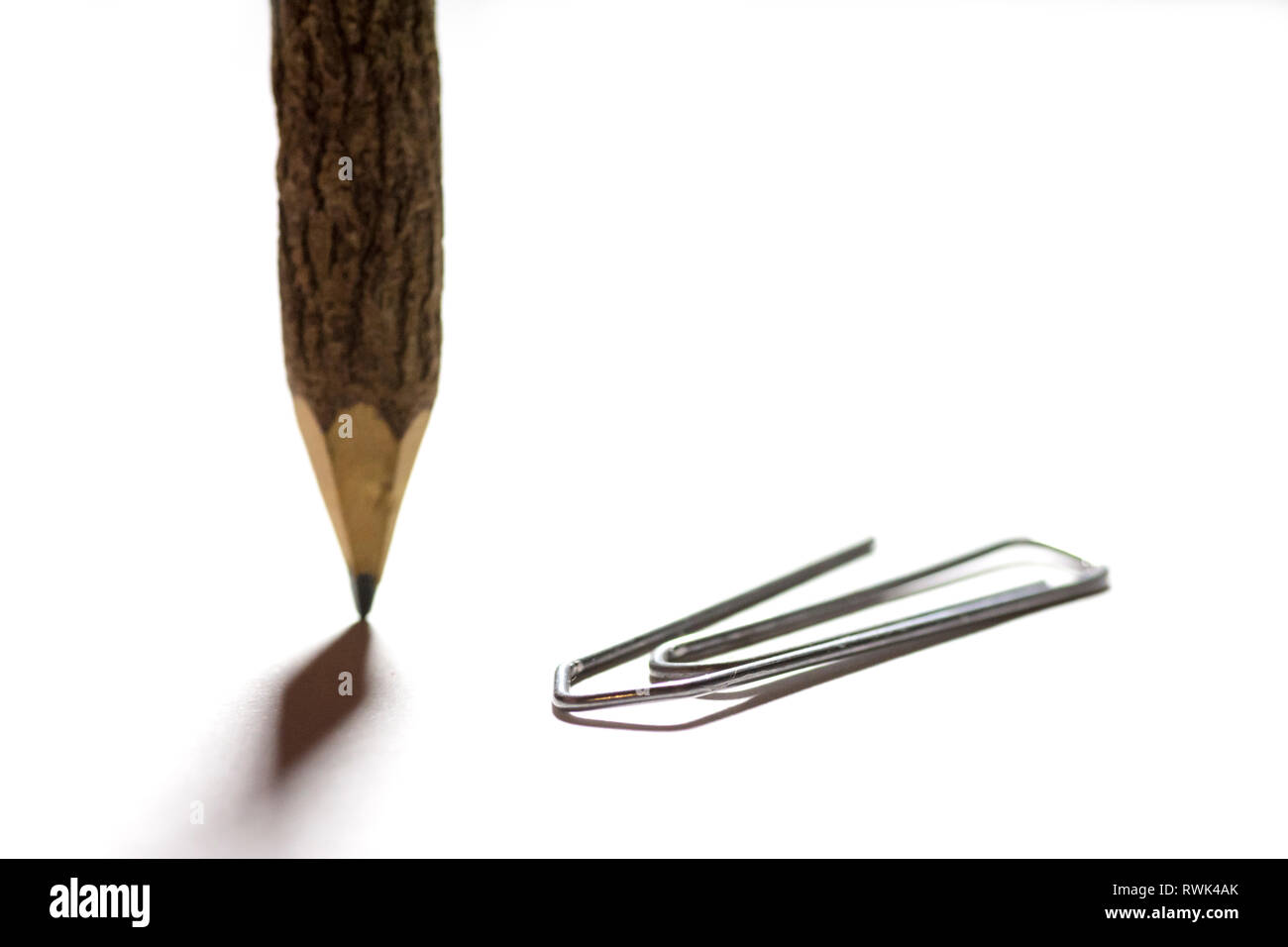 single paper clip with wooden pencil in white background Stock Photo ...