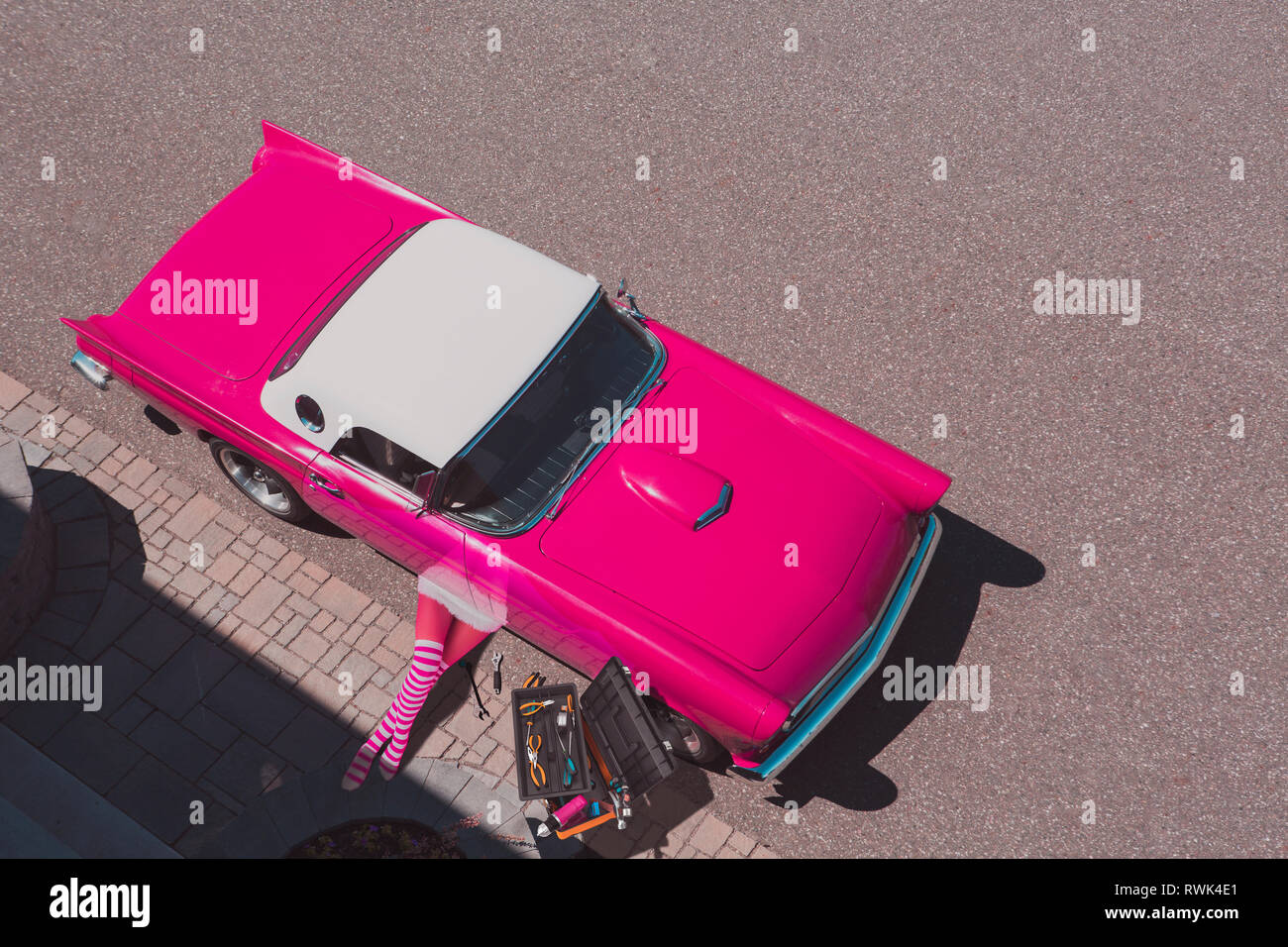 A pink Thunderbird being repaired by a woman, composite image Stock Photo