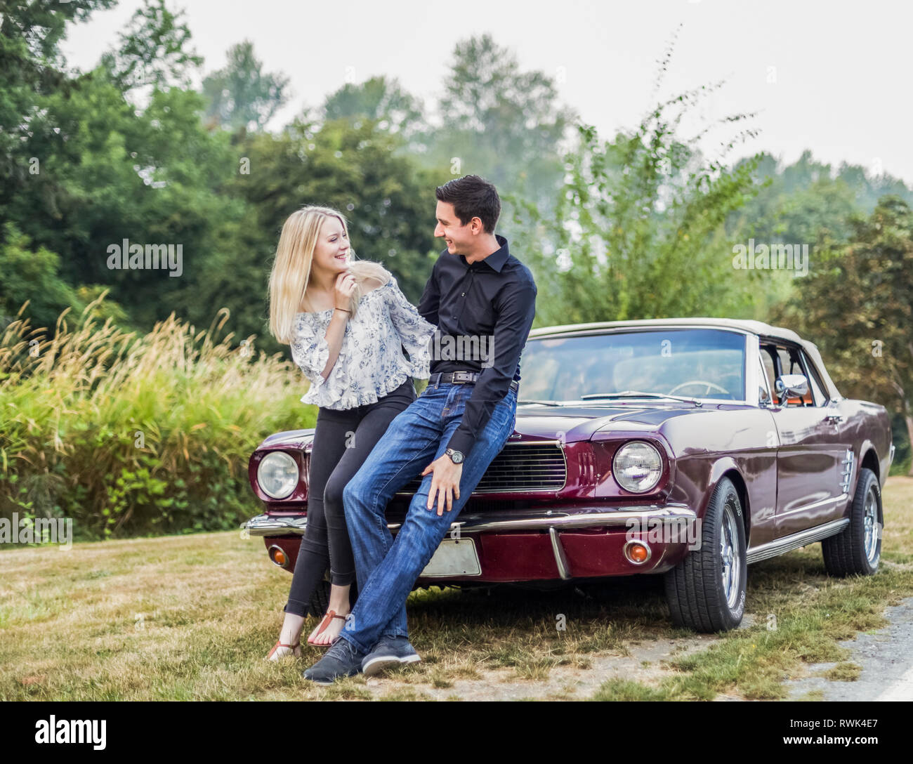 A young couple standing with a vintage sports car; Bothell, Washington