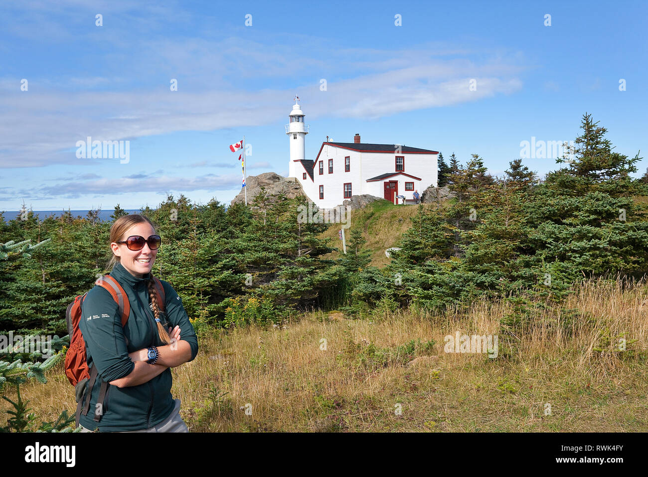 Parks Canada interpreter in front of the Lobster Cove Head Lighthouse and the lighthouse keeper's home which now serves as an interpretive exhibit. Rocky Harbour, Gros Morne National Park, Newfoundland, Canada Stock Photo
