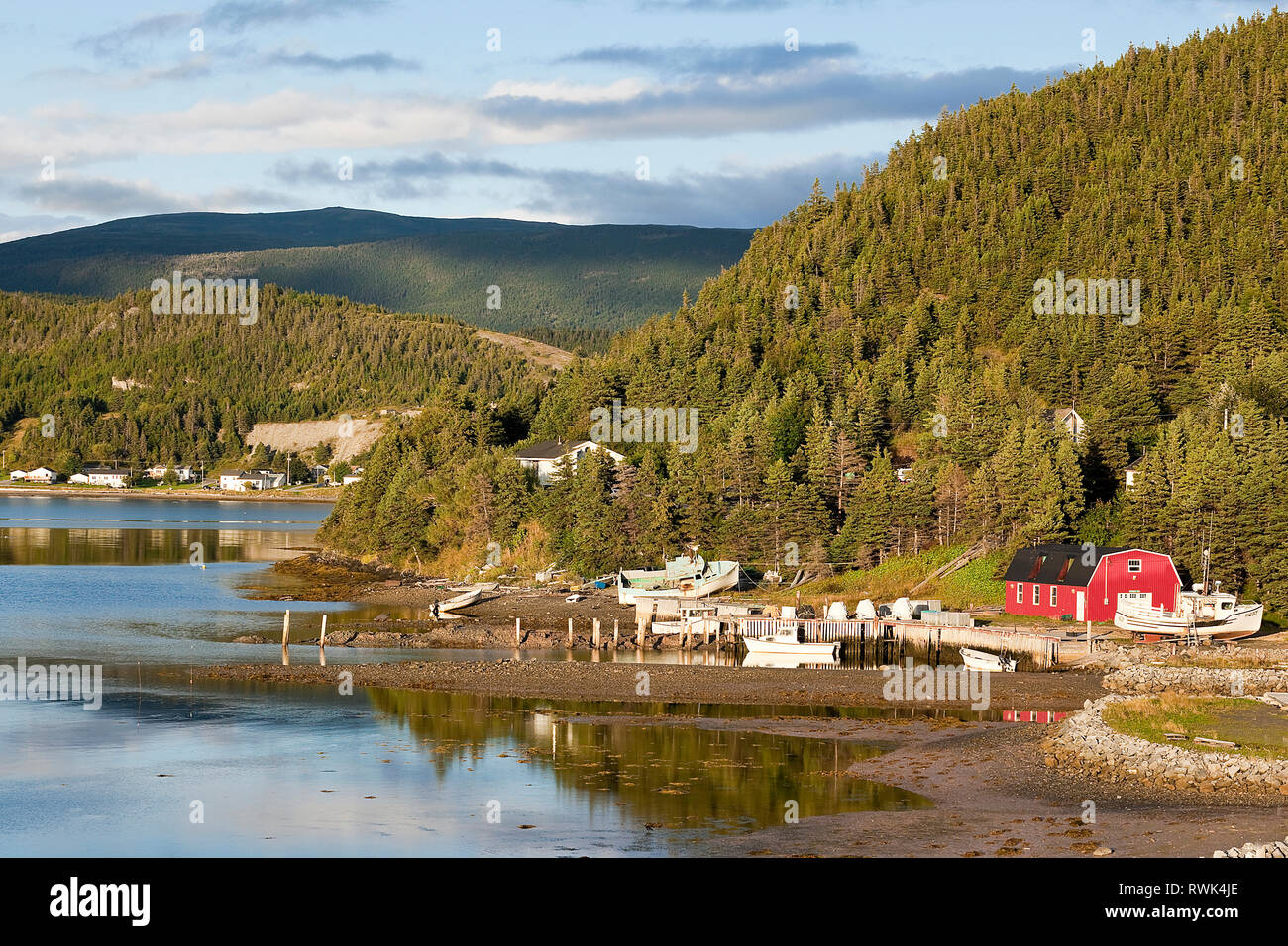 Homes spread out at the foot of mountainous terrain along the shore of Neddies Harbour, Norris Point,Gros Morne National Park, Newfoundland, Canada Stock Photo