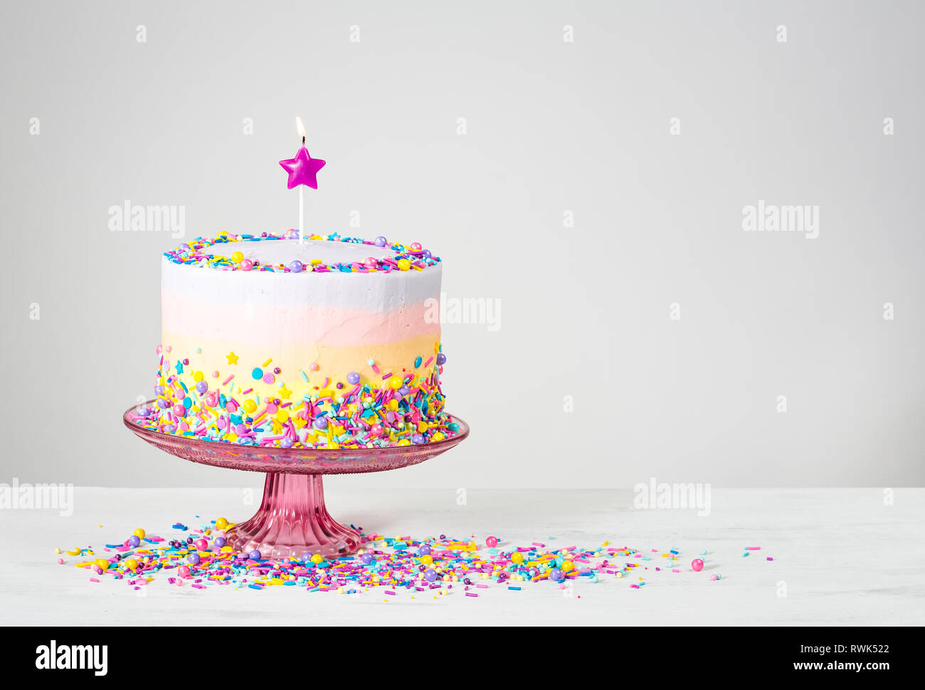 Birthday cake with star candle and colorful sprinkles Stock Photo - Alamy