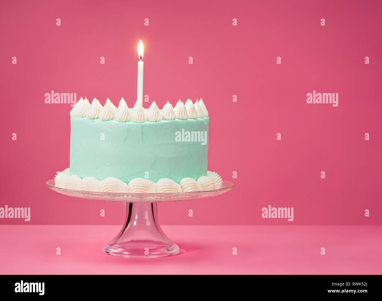 Pastel blue birthday cake over pink background with one candle Stock ...