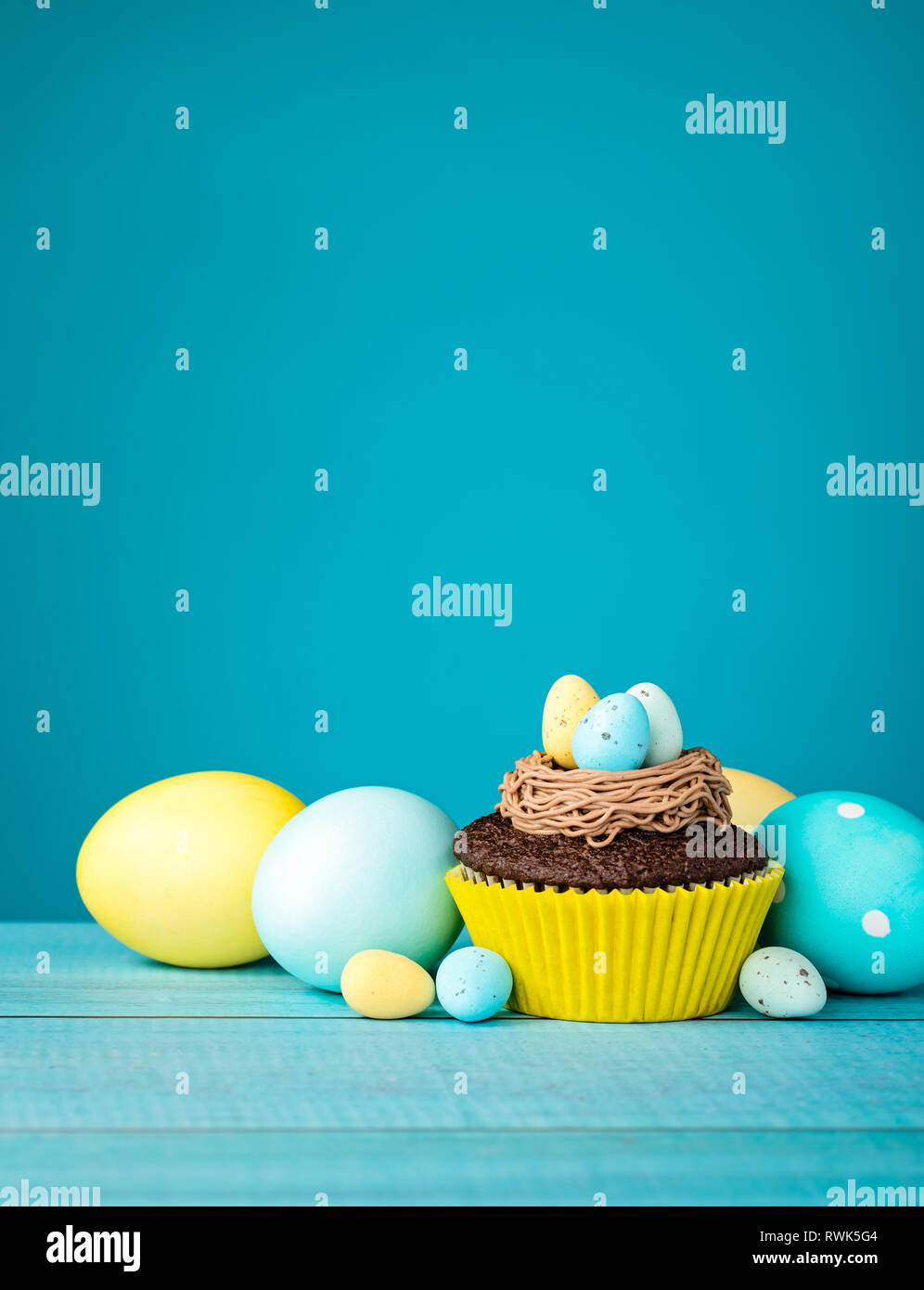 Easter Eggs and cupcake with Candy on a blue background. Stock Photo