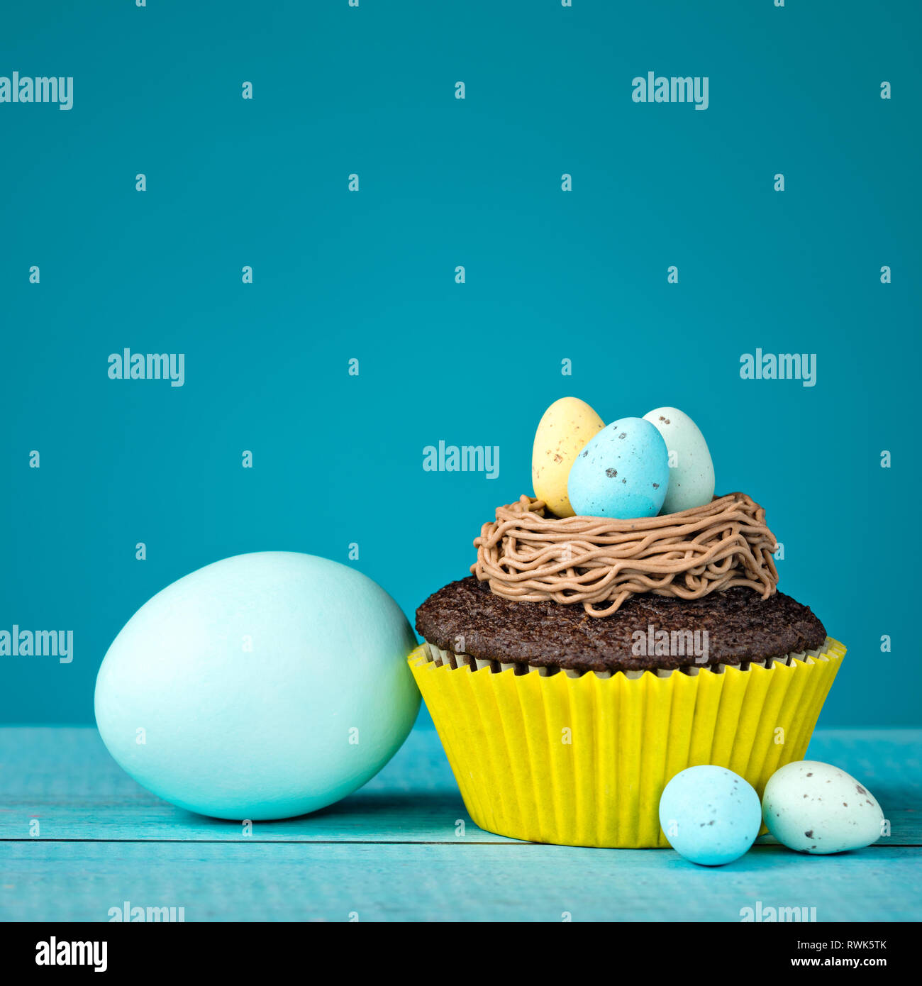 Easter Eggs and cupcake with Candy on a blue background. Stock Photo
