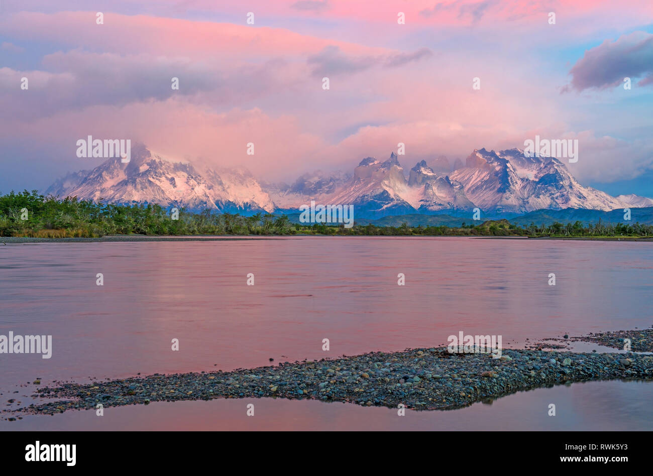 Pink sunrise along the Serrano river with the snowcapped peaks of Torres del Paine national park in the background, Patagonia, Chile. Stock Photo