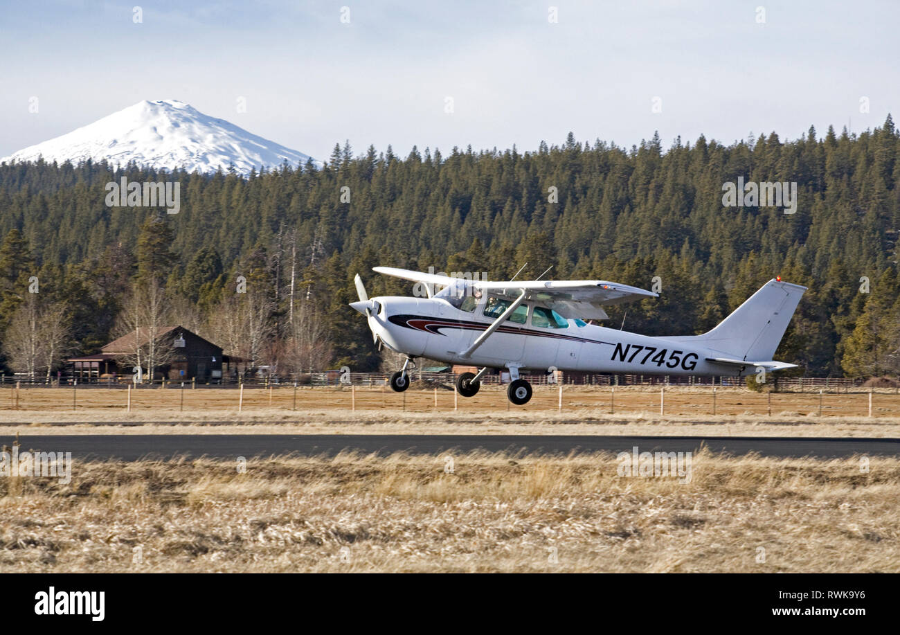 A single-engine, single wing Cessna Skyhawk, the most popular small aircraft among pilot instructors in the world, makes touch and go landings at a sm Stock Photo