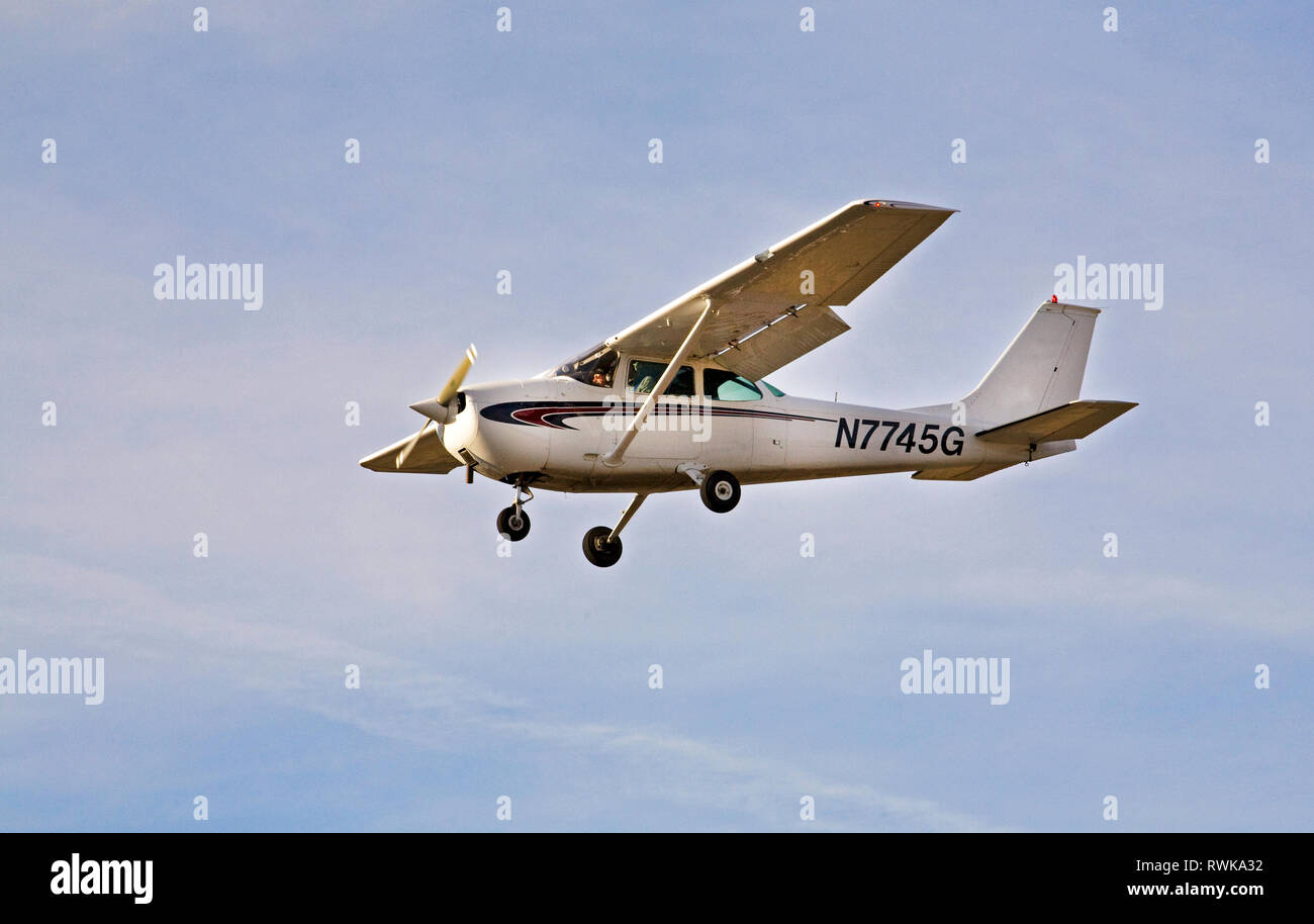 A single-engine, single wing Cessna Skyhawk, the most popular small aircraft among pilot instructors in the world, makes touch and go landings at a sm Stock Photo