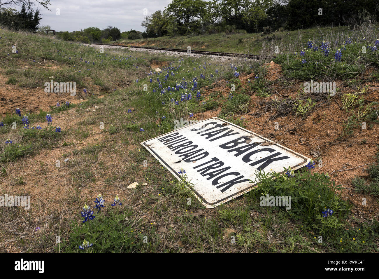 Stay back railroad track sign on the ground in Hill Country, Texas, USA Stock Photo