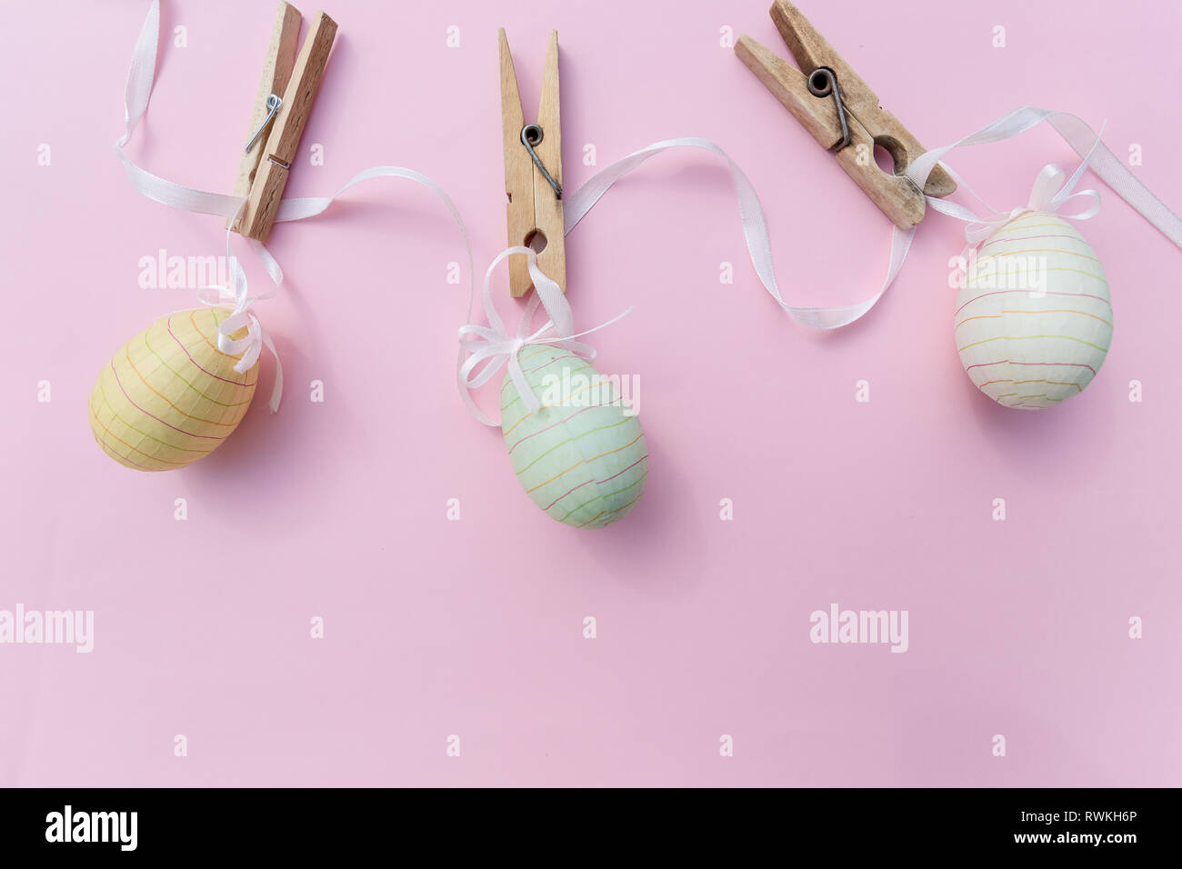 Many easter eggs on trendy pink pastel background. Eggs are hand-drawn. Flat lay style.Top view of easter eggs colored in differen patterns. Various Stock Photo