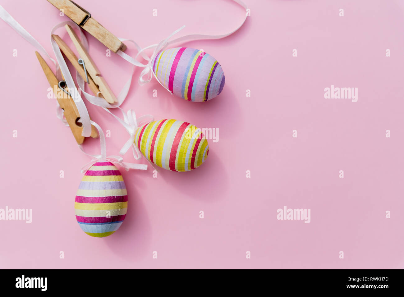 Many easter eggs on trendy pink pastel background. Eggs are hand-drawn. Flat lay style.Top view of easter eggs colored in differen patterns. Various Stock Photo