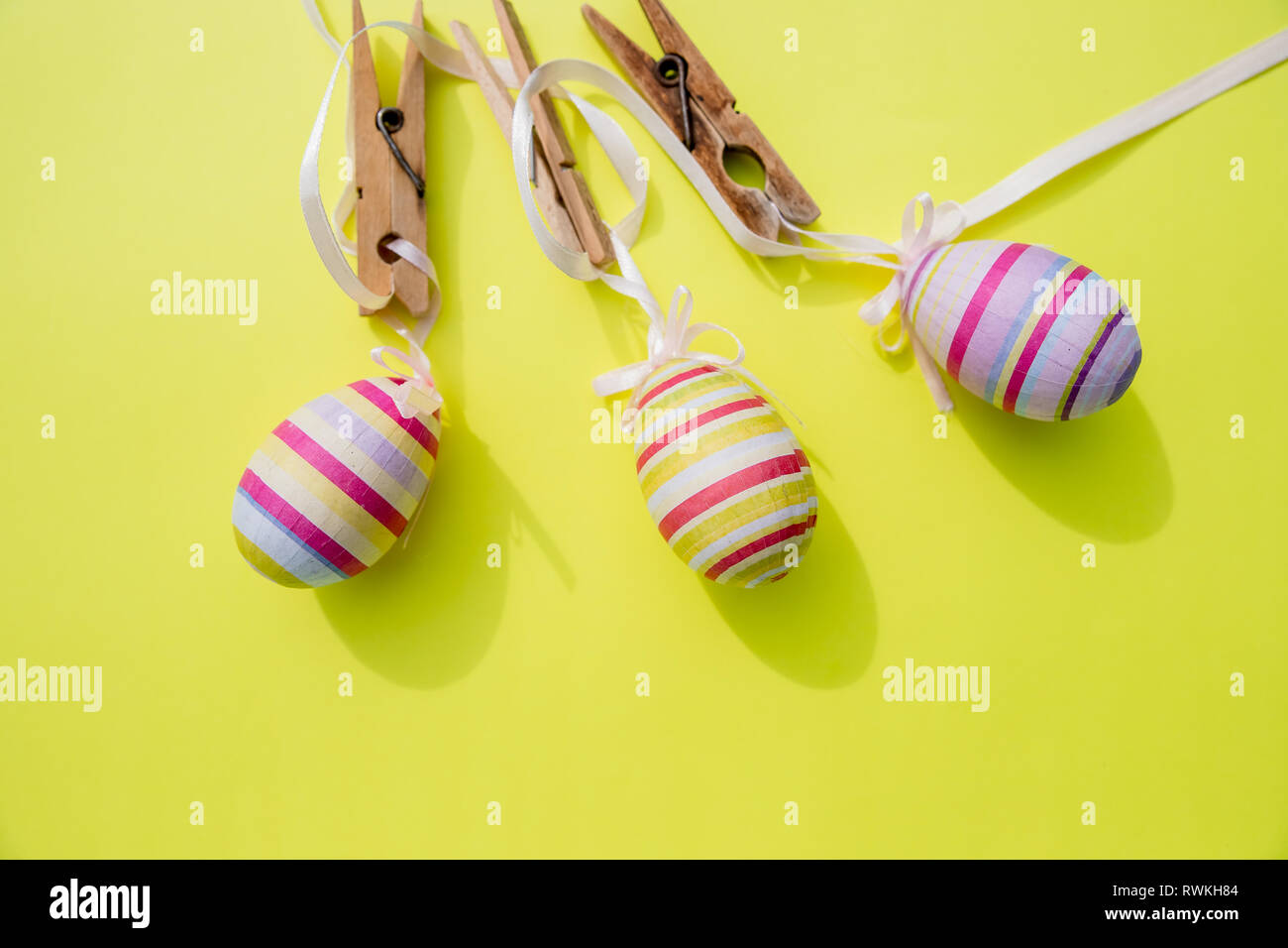 Eggs painted various patterns for Easter holiday. Yellow bright background, copy space, minimalistic concept.Stylish Candy color easter eggs .Spring Stock Photo