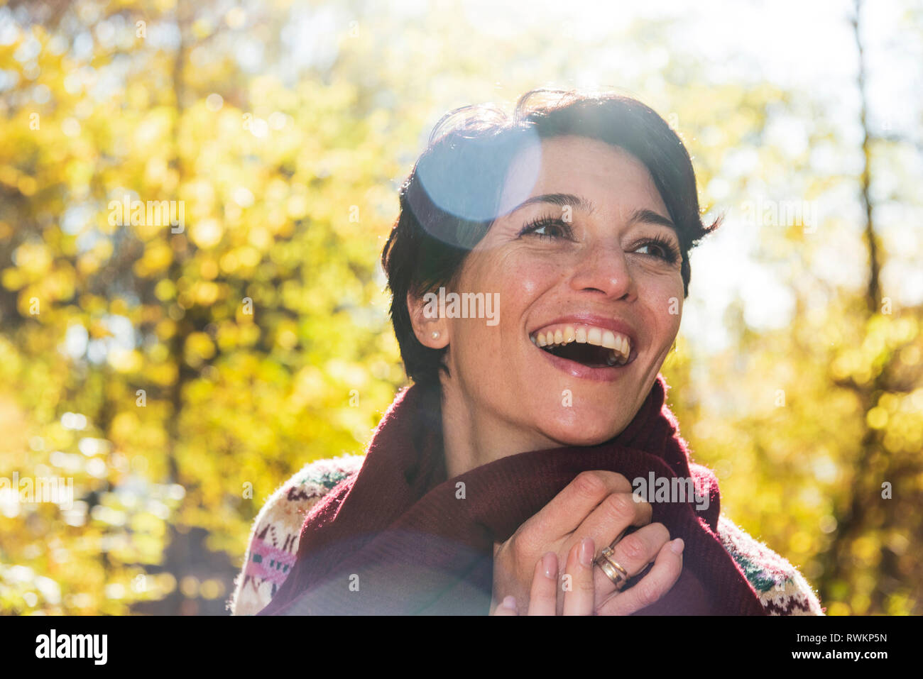 Smiling woman in autumnal forest Stock Photo