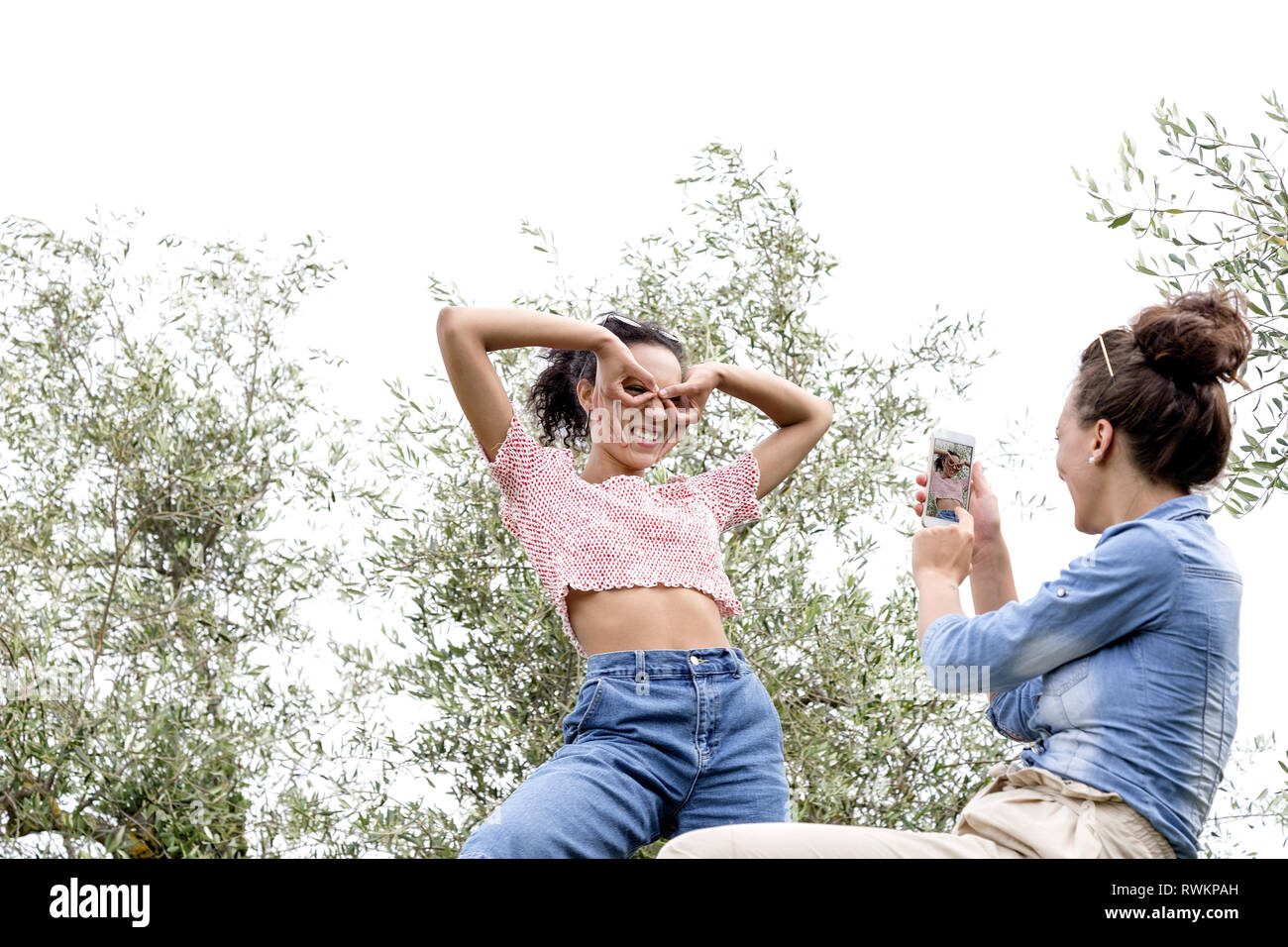 Woman taking photo of friend making faces Stock Photo