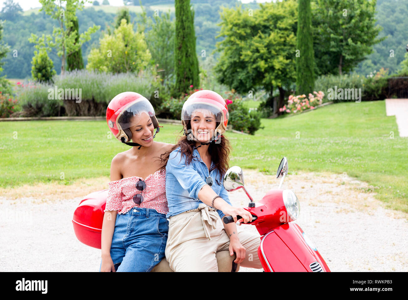 Women on scooter in countryside, Città della Pieve, Umbria, Italy Stock Photo