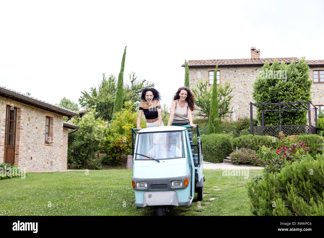 Friends on three-wheeler vehicle, Città della Pieve, Umbria, Italy Stock Photo