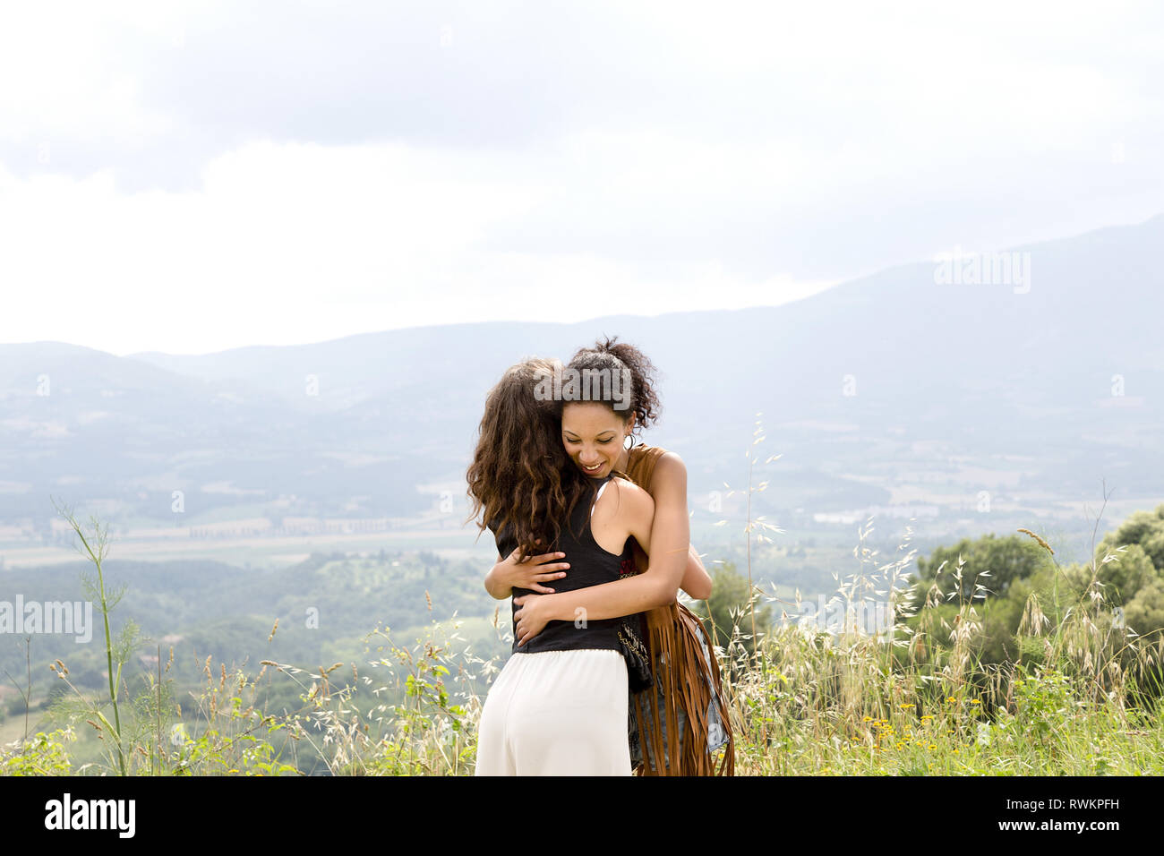 Friends hugging on hilltop, Città della Pieve, Umbria, Italy Stock Photo