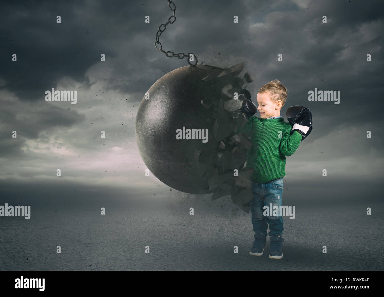Power and determination of a child against a wrecking ball Stock Photo