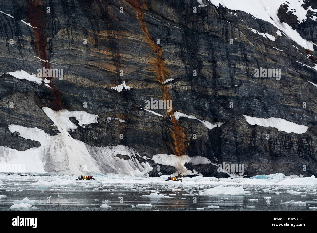 Tourists in dinghys near coastline, distant view, Burgerbukta, Spitsbergen, Svalbard, Norway. Stock Photo
