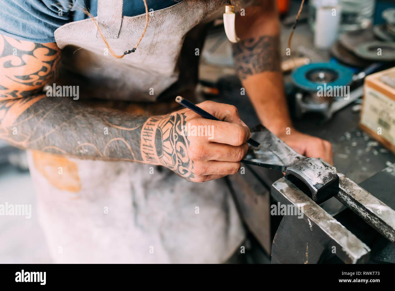 Axe maker using steel grinder in workshop Stock Photo