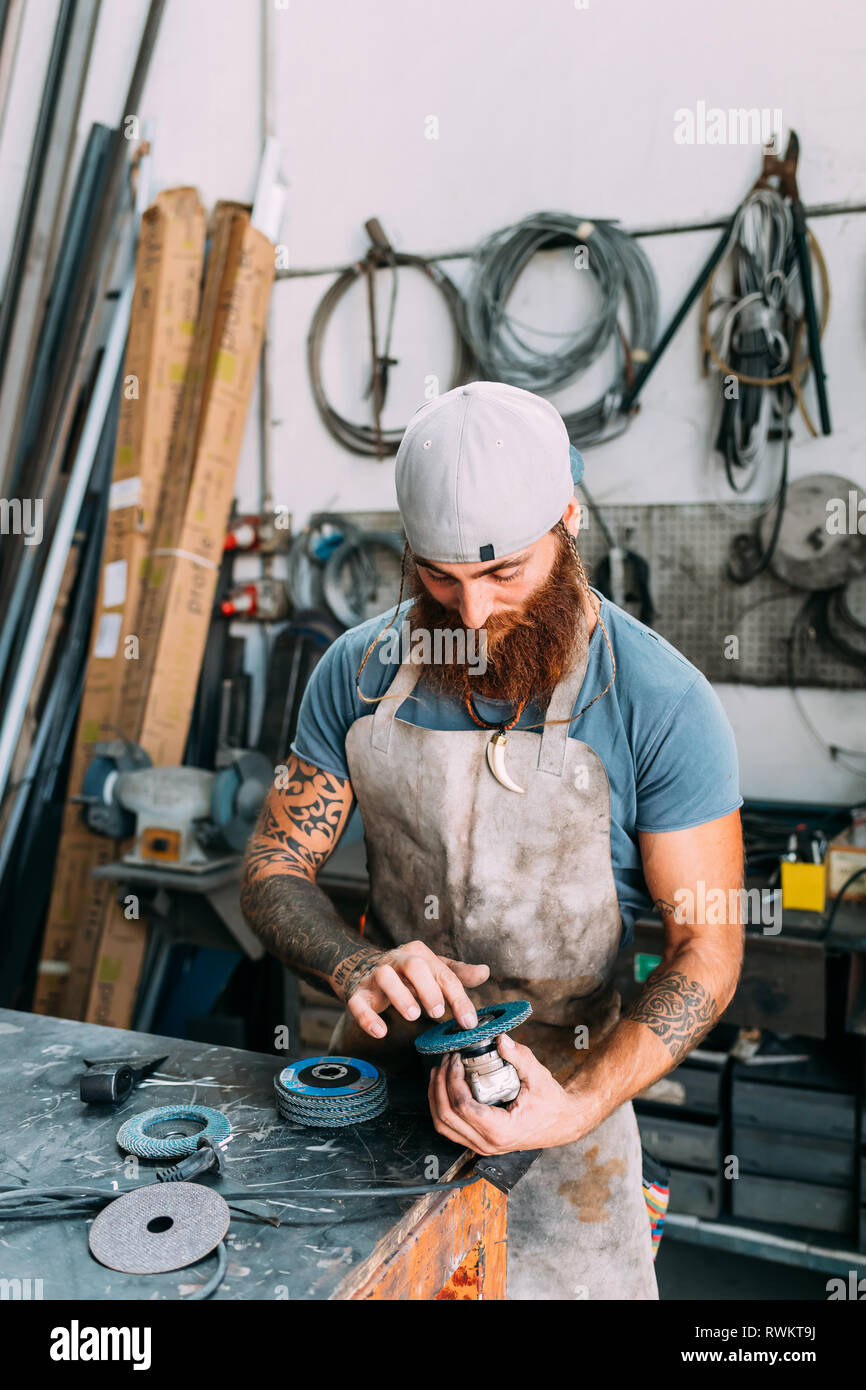 Axe maker using steel grinder in Stock Photo Alamy