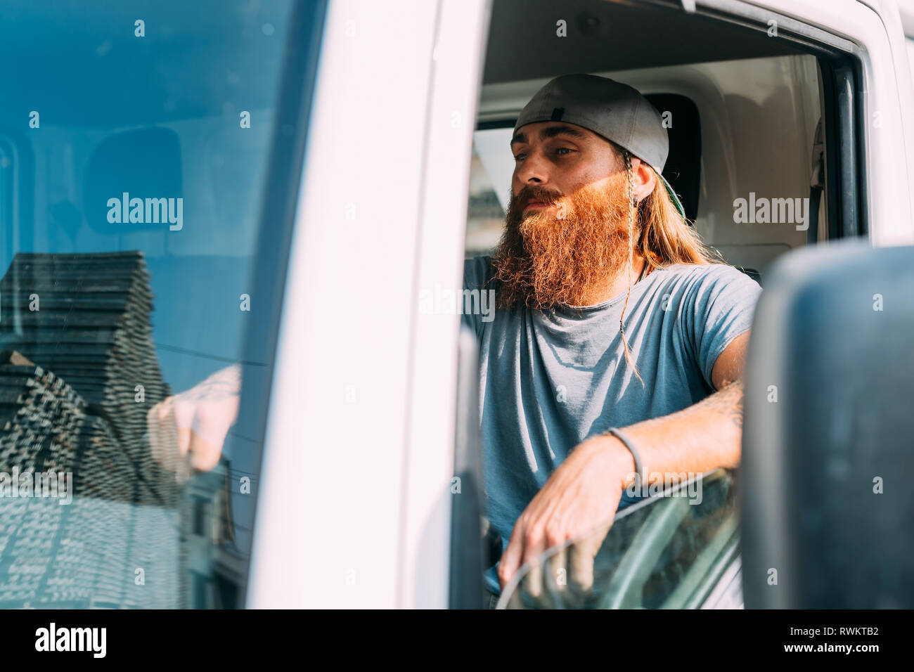 Man in commercial vehicle in industrial yard Stock Photo