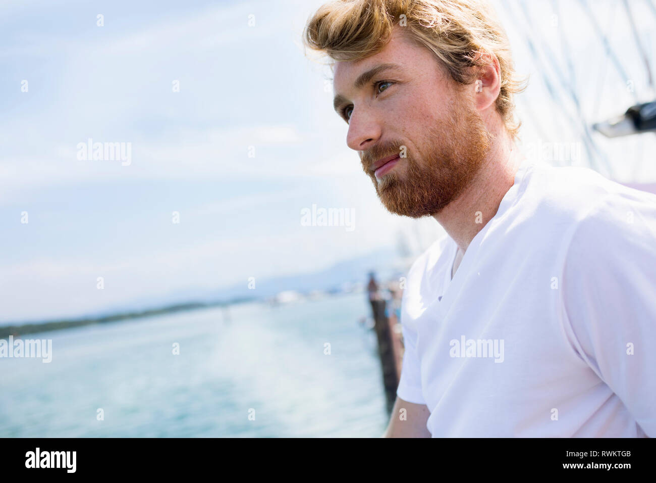 Young man on sailboat on Chiemsee lake, Bavaria, Germany Stock Photo